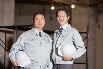 ヘルメットを持って並ぶ社員2名